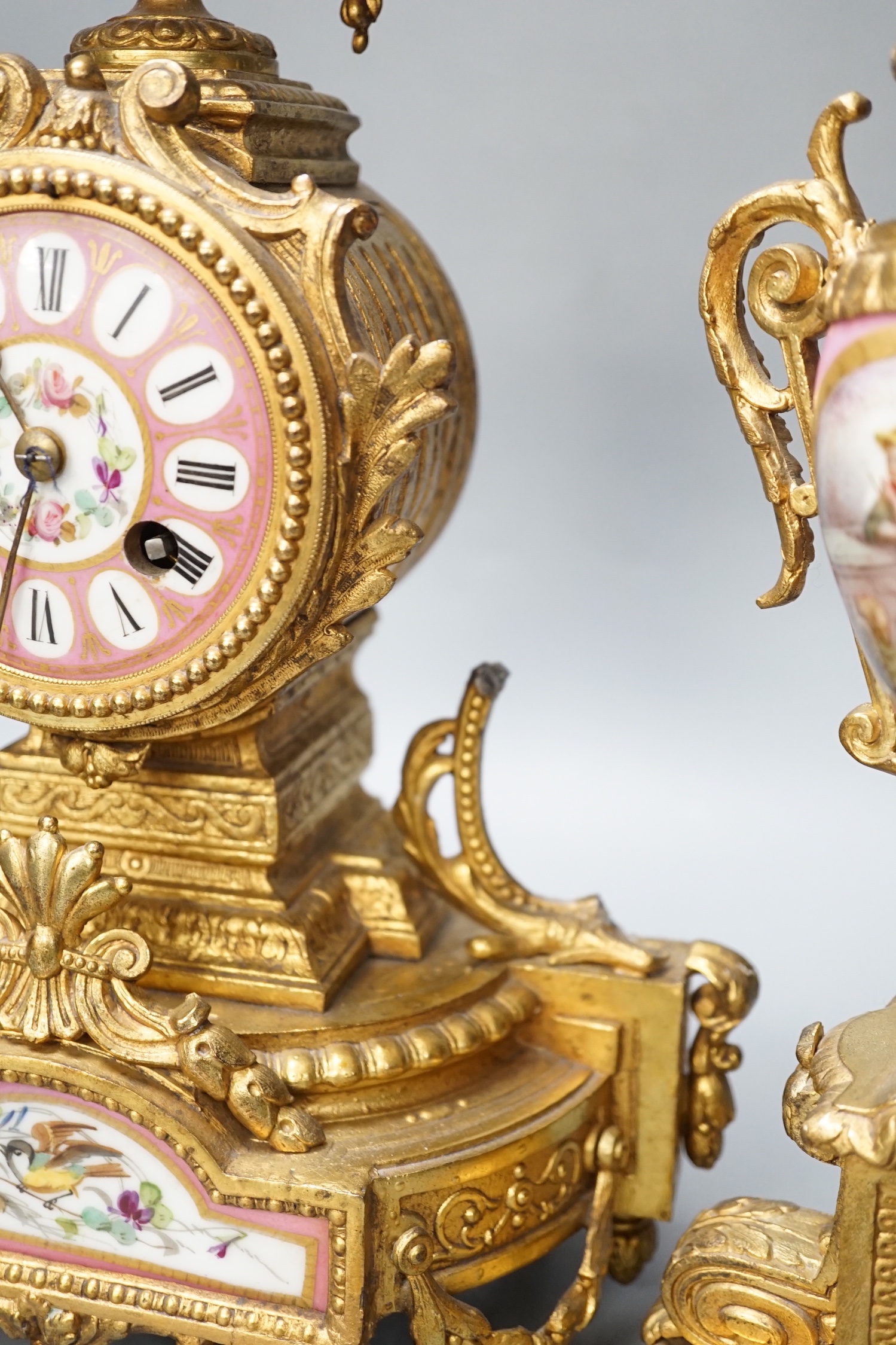 A French gilt metal and porcelain clock garniture. 36.5cm